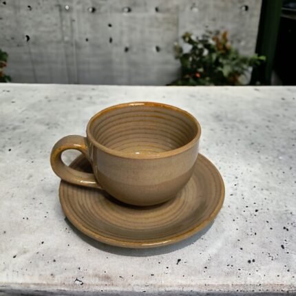 Brown ceramic tea cup with matching saucer