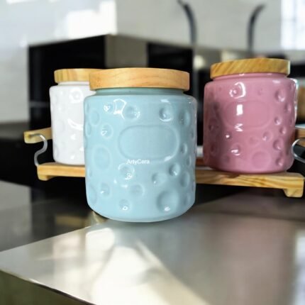 White green and pink ceramic kitchen storage jars with wooden lids