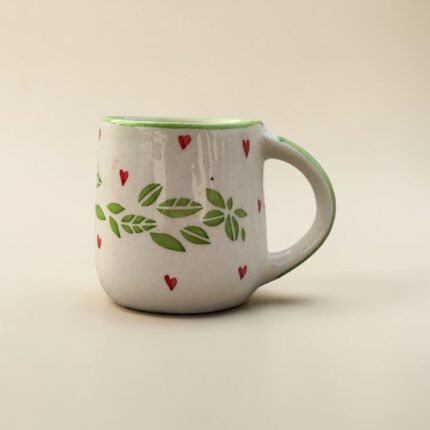 Ceramic tea and coffee mug with green leaf and red heart artwork