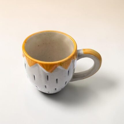 Hand-painted yellow ceramic mug with strawberry shaped saucer