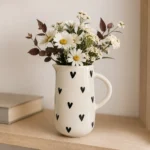 White ceramic heart jug with black hearts used as a flower vase
