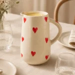 Handpainted red heart ceramic jug on a dining table