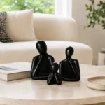 Black glossy ceramic father mother and child sculpture set displayed together