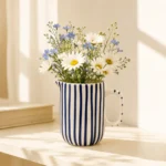 Blue striped ceramic mini jug used as a small flower vase