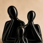 Close-up of glossy black ceramic father mother and child family figures