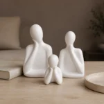 Ceramic father mother and child sculpture set displayed together