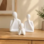 Minimalist white ceramic father mother and child figures styled in a home interior