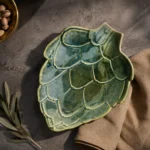 Green ceramic serving platter with artichoke leaf design viewed from above