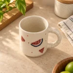 Hand-painted Watermelon Splash ceramic mug shown from a 60 degree angle with handle and glaze visible